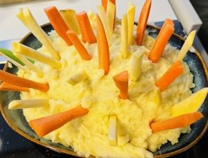 Gulerotstenger og kålrotstenger som står i ei gryte med plukkfisk