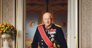 Kong Harald V står i gallauniform inne på slottet