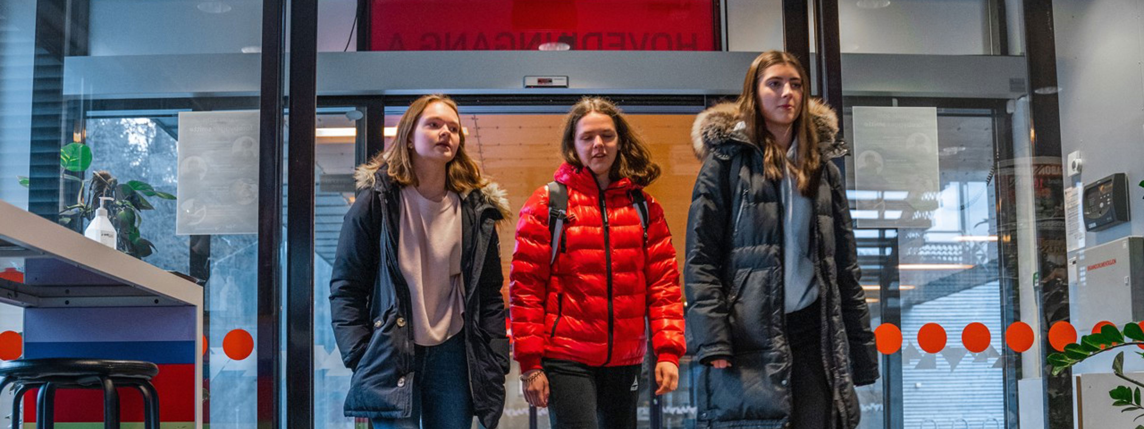 Tre jenter går inn houvidinngangen på skulen